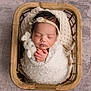 newborn, baby, sleeping, basket, blanket, knitted_toy, bunny, headband, floral, soft_texture, peaceful, swaddled, infant, cute, portrait, indoors, wooden, hands, cozy, rest