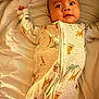 Sire is registered to the contest to win money with this photo: baby, infant, onesie, animal_print, bed, blanket, sleepwear, cute, face, arms, lying_down, child, soft_lighting, indoors, portrait, expression, young, comfortable, cozy, sleep