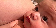Sire is registered to the contest to win money with this photo: baby, infant, face, skin, water_droplets, tattoo, shoulder, close_up, portrait, curious, bath, wet_skin, person, child, indoors, expression, cute, human, newborn, soft_light