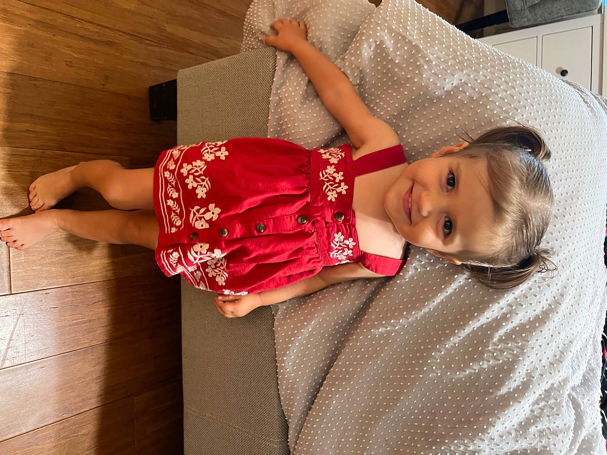 Elle is registered to the contest to win money with this photo: baby, baby_toddler_clothing, child, floor, flooring, fun, happy, hardwood, human_leg, joy, pattern, person, skin, sleeve, smile, t_shirt, textile, thigh, toddler, trunk