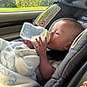 Grayson is registered to the contest to win money with this photo: baby, bottle, car_seat, blanket, infant, feeding, child, window, car_interior, seat, person, milk, relaxing, young_child, cute, cozy, transportation, child_seat, daylight, comfort
