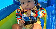 Kamari is registered to the contest to win money with this photo: baby, child, pool, inflatable, swimsuit, hat, sunhat, water, blue, summer, outdoor, playful, tongue_out, sitting, cute, colorful, sunny, vacation, toddler, fun