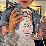 Skye joined the competition — help win amazing prizes! baby, child, denim_jacket, white_shirt, colorful_text, happy, smiling, indoor, hands, person, television, light, furniture, pants, feet, long_sleeves, celebration, father_day, cute, portrait