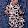 baby, infant, child, floral_outfit, blue_blanket, cute, portrait, smiling, curious, clothing, lying_down, hands, feet, skin, face, eyes, head, buttoned_shirt, fabric, indoor