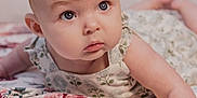 Skylar joined the competition — help win amazing prizes! baby, infant, child, face, eyes, skin, arm, blanket, floral_pattern, clothing, cute, lying_down, portrait, indoor, soft_lighting, young, person, expression, looking_up, curious