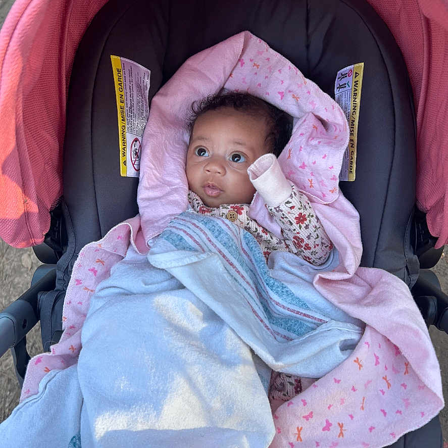 Milayah joined the competition — help win amazing prizes! baby, blanket, child, clothing, cozy, curious, cute, face, infant, outdoor, person, pink, portrait, resting, seat, small_hand, soft, stroller, wrapped, young