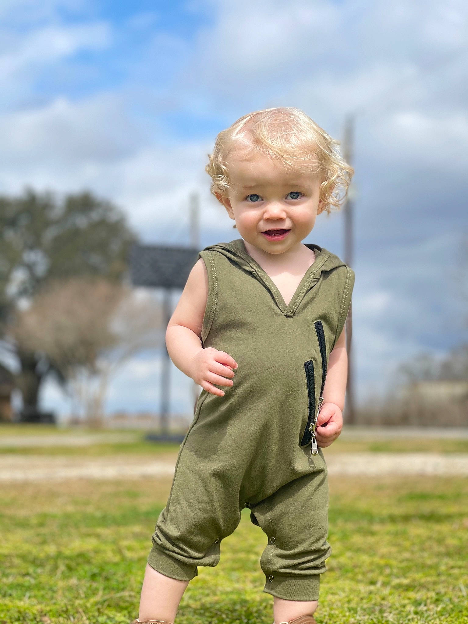 Cutler is registered to the contest to win money with this photo: baby_toddler_clothing, blond, cloud, eye, face, flash_photography, gesture, grass, grass_family, grassland, happy, landscape, meadow, people_in_nature, person, plant, prairie, sky, sleeve, toddler