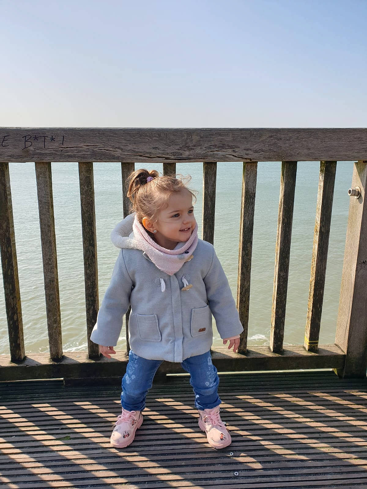 Noëlyne participe au concours pour gagner de l'argent avec cette photo : baby_toddler_clothing, child, denim, dock, fence, fun, happy, joy, leisure, outerwear, people_in_nature, person, sitting, sky, sleeve, standing, toddler, tree, walking, water