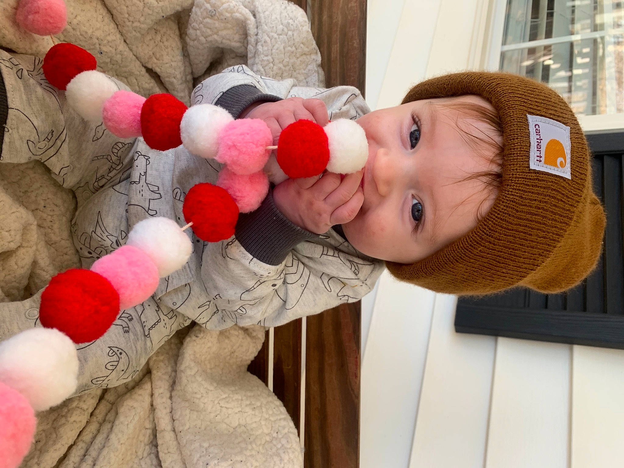Corbin is registered to the contest to win money with this photo: baby, cap, cheek, child, fun, happy, hat, leisure, lip, nose, party_supply, person, red, skin, smile, stuffed_toy, sun_hat, textile, toddler, tree