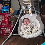 Alexander joined the competition — help win amazing prizes! baby, baby_swing, infant, indoor, floor, diapers, boxes, scooter, toy, plush_toy, wooden_floor, person, clothing, footwear, face, expression, seat, blanket, comfort, home