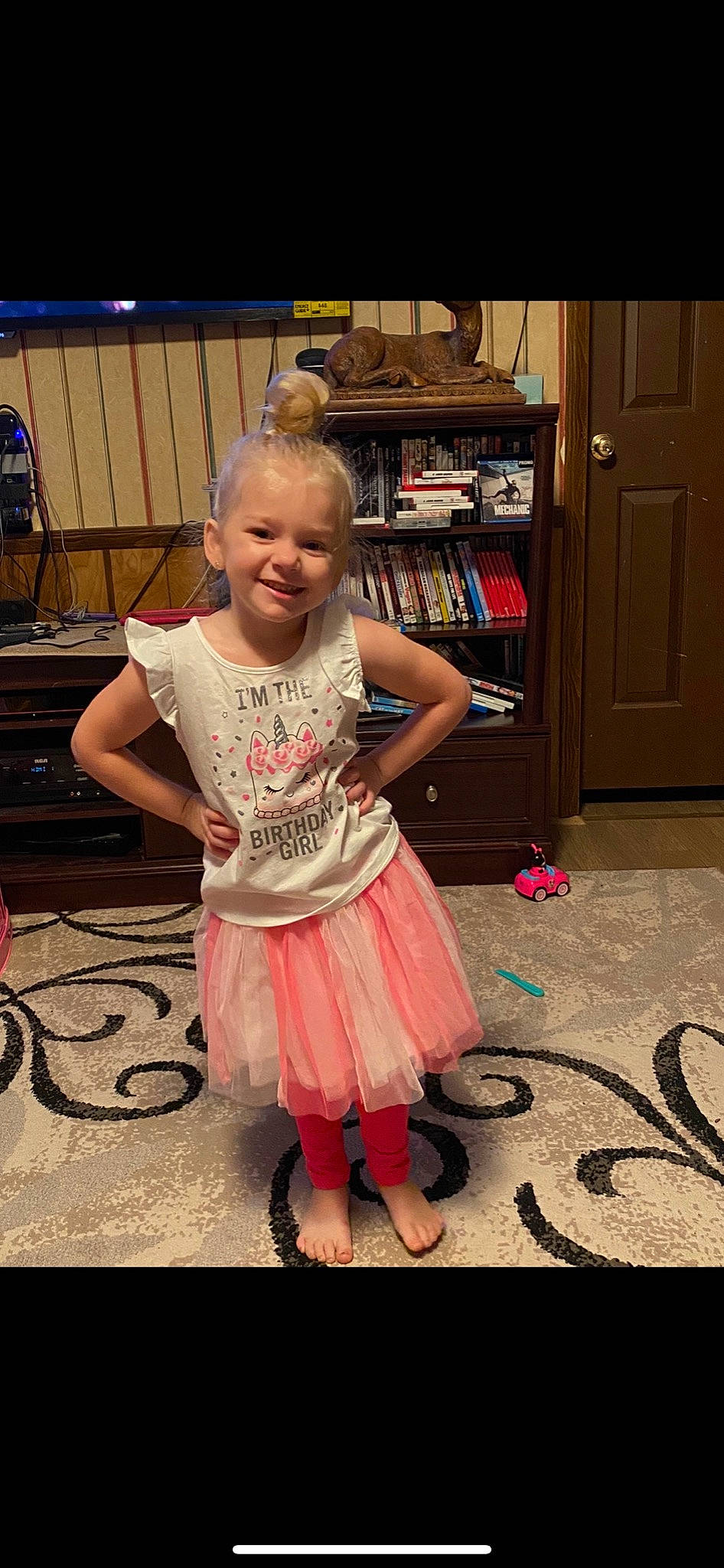 Charity is registered to the contest to win money with this photo: baby_toddler_clothing, bookcase, cabinetry, child, door, floor, flooring, fun, hairstyle, happy, hardwood, iris, joy, pattern, person, pink, purple, shelf, smile, standing