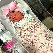 Angelie joined the competition — help win amazing prizes! baby, bed, blanket, child, cute, face, hat, headwear, hospital_bassinet, indoors, infant, newborn, pacifier, peaceful, pink_bow, resting, sleeping, small, soft_lighting, wrapped