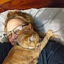Molly joined the competition — help win amazing prizes! woman, cat, glasses, bed, pillow, orange_tabby, hair, paw, resting, indoor, closeup, sleepy, affection, pet, casual, comfort, relaxation, feline, human, cuddle