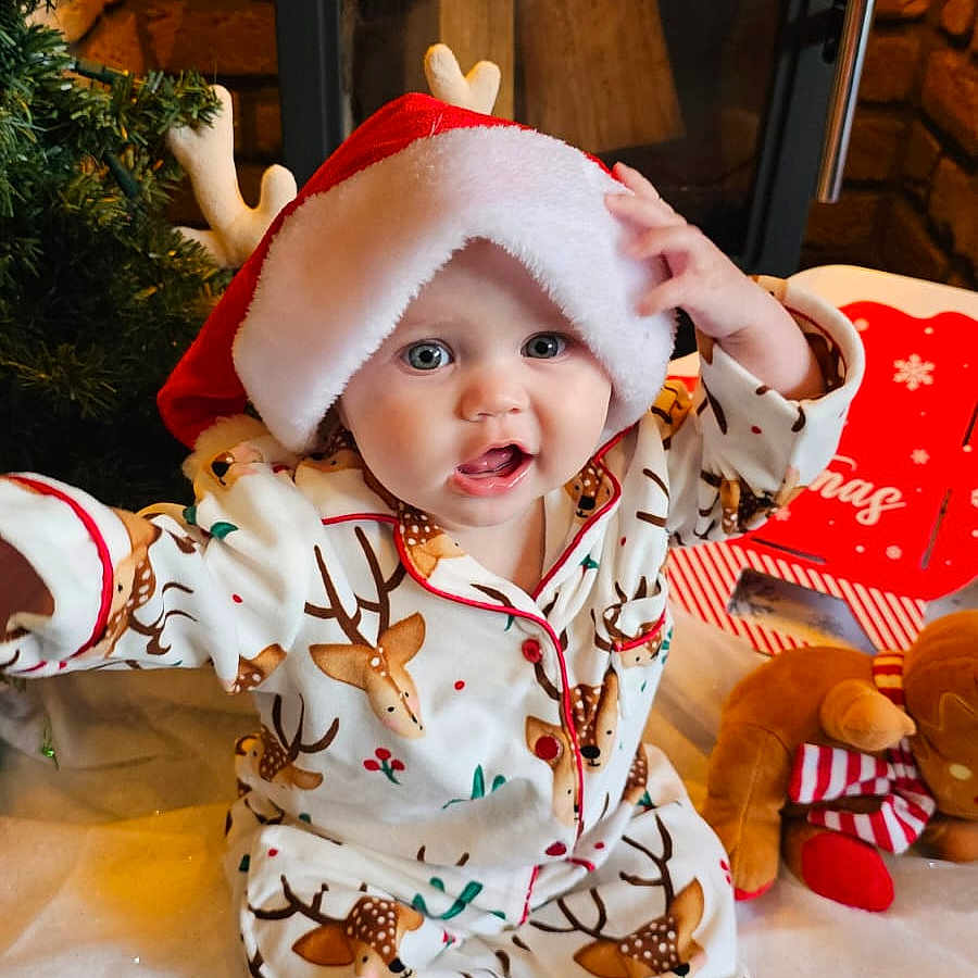 Raya is registered to the contest to win money with this photo: architecture, baby, building, clothing, costume, dress, face, fireplace, furniture, hat, head, hood, indoors, livingroom, person, photography, plant, portrait, pottedplant, room