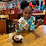 Summer is registered to the contest to win money with this photo: birthday, bow, celebration, child, dessert, diner, food, girl, happy, ice_cream, indoor, pajamas, people, restaurant, sash, smile, sprinkles, table, whipped_cream, wood