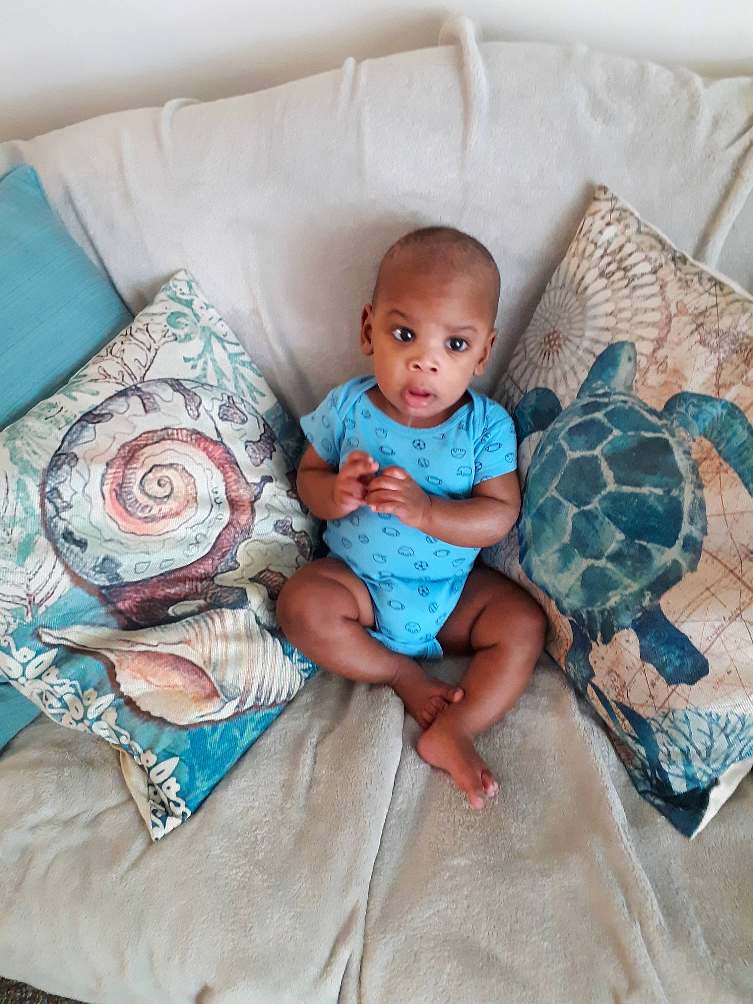 Jabari joined the competition — help win amazing prizes! baby, bed_sheet, bedding, blanket, child, comfort, cushion, furniture, linens, pattern, person, pillow, product, quilt, room, textile, toddler, turquoise