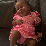 Sahara joined the competition — help win amazing prizes! baby, child, couch, cozy, cute, furniture, happy, home, indoor, infant, pacifier, person, pink_dress, playful, portrait, relaxed, sitting, smiling, toddler, white_socks