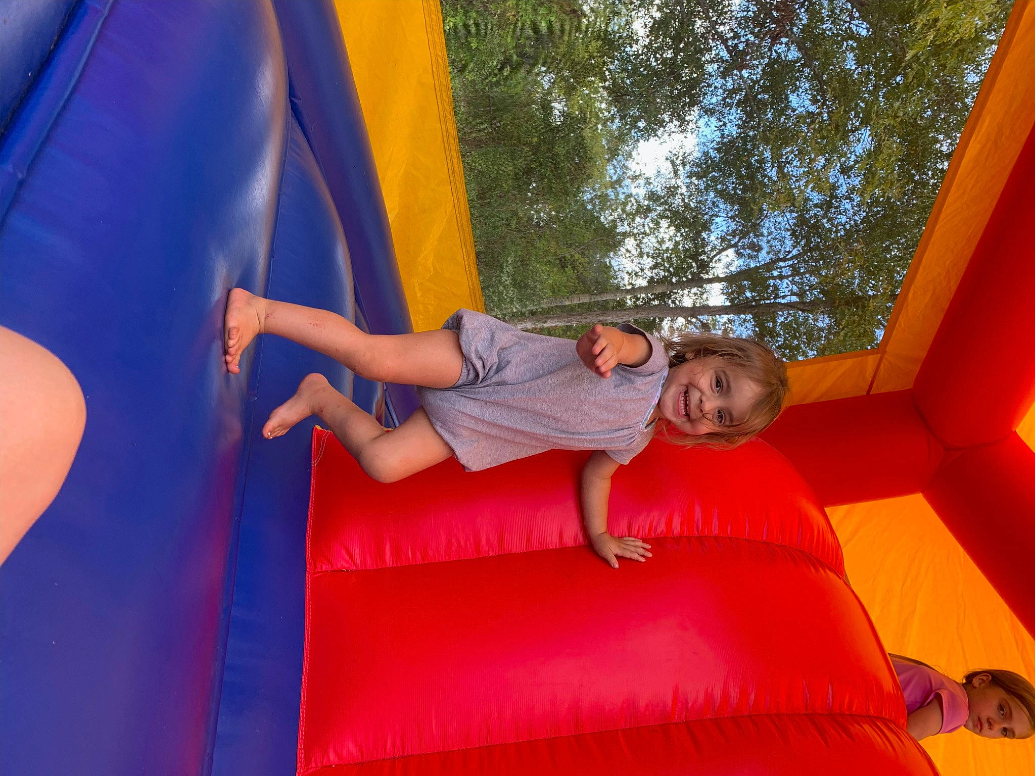 Rosalie is registered to the contest to win money with this photo: bounce_house, chute, city, comfort, electric_blue, fun, grass, human_body, joy, leg, leisure, outdoor_play_equipment, person, playground, playground_slide, public_space, recreation, shorts, smile, toddler