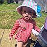 toddler, child, swimsuit, sun_hat, red_gingham, strawberry_patch, outdoor, backyard, grass, pavement, plastic_toy, sunny, daylight, curious, barefoot, person, portrait, summer, play, garden_fence