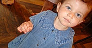 Wren is registered to the contest to win money with this photo: toddler, child, denim_dress, blue_eyes, curly_hair, balloon, wooden_floor, indoor, person, feet, legs, footwear, casual, standing, curious, portrait, light, hand, smile, background