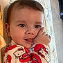 baby, child, cute, pajamas, hello_kitty, pattern, mat, indoor, face, hand, tongue, playing, lying_down, infant, smile, clothing, young_child, floor, person, eyes