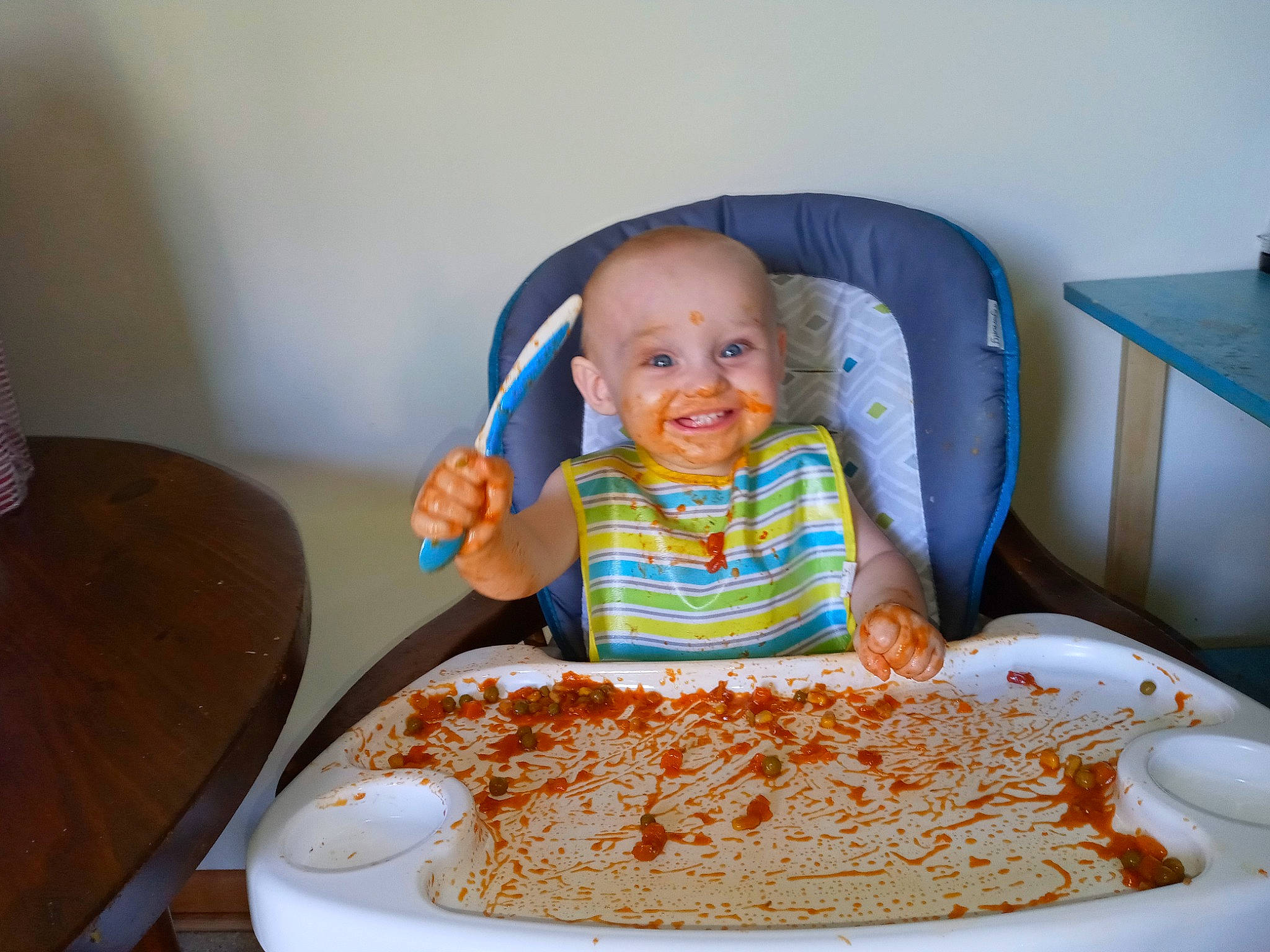 Maurice is registered to the contest to win money with this photo: baby, baby_playing_with_food, baby_toddler_clothing, chair, comfort_food, cuisine, dish, dishware, event, food, ingredient, joy, person, plate, recipe, sharing, smile, sweetness, t_shirt, table