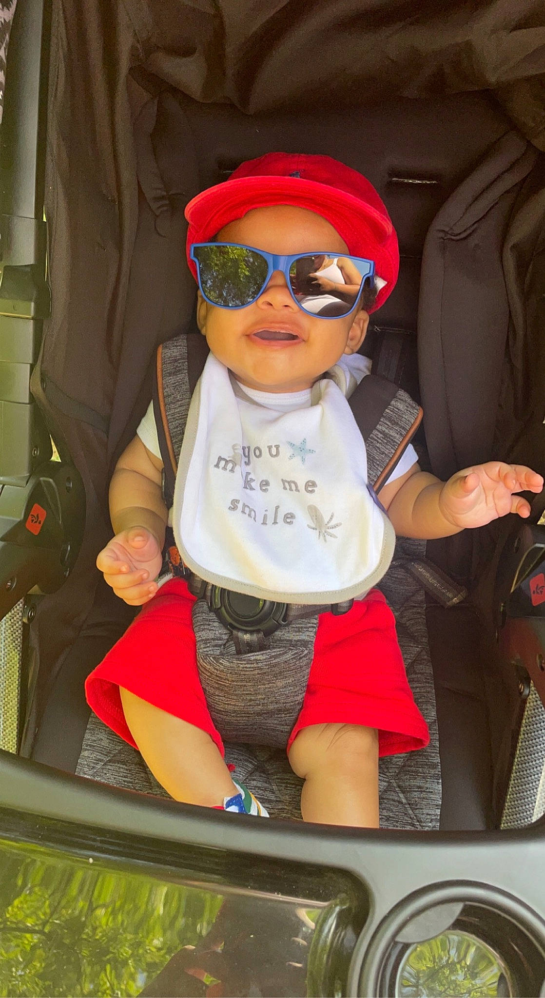 Izaiah is registered to the contest to win money with this photo: automotive_design, automotive_exterior, baby, baseball_cap, bumper, cap, car_seat, child, eyewear, fun, glasses, goggles, hat, headwear, motor_vehicle, person, personal_protective_equipment, sunglasses, t_shirt, toddler