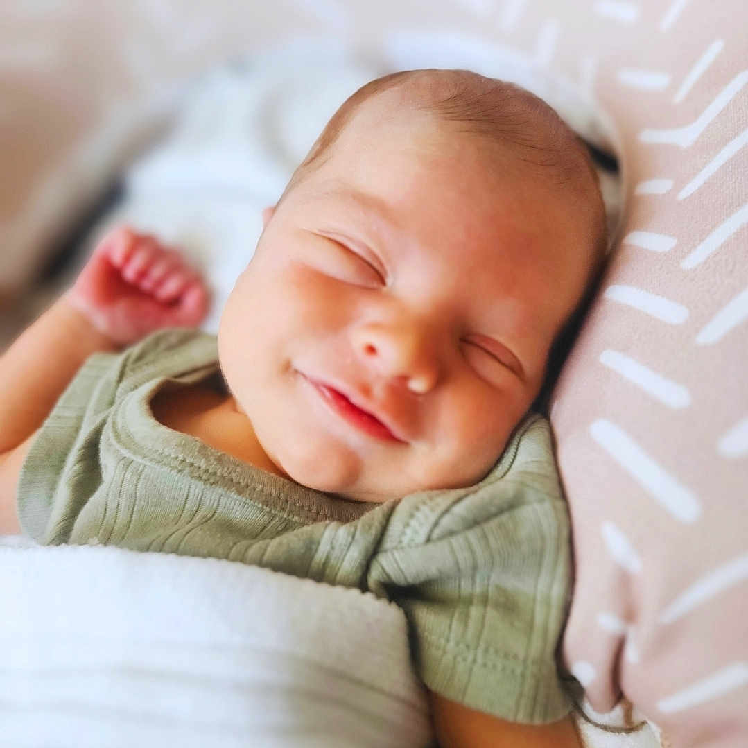 Grayson-Connor is registered to the contest to win money with this photo: baby, blanket, child, closeup, clothing, comfort, cute, face, happy, indoors, infant, newborn, peaceful, pillow, portrait, relaxation, rest, sleeping, smile, soft