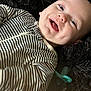 Michael joined the competition — help win amazing prizes! adorable, baby, black_fur, child, closeup, cozy, cute, dimples, face, happy, indoors, infant, lying_down, pacifier, playful, portrait, smiling, soft_texture, striped_clothing, young