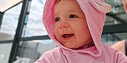 Victoria a rejoint le concours — aidez-le/la à gagner de superbes lots ! baby, building, cartoon_clothing, child, closeup, cute, daylight, eyelashes, face, glass, hand, happy, hood, outdoor, person, pink_towel, reflection, skin, smiling, window