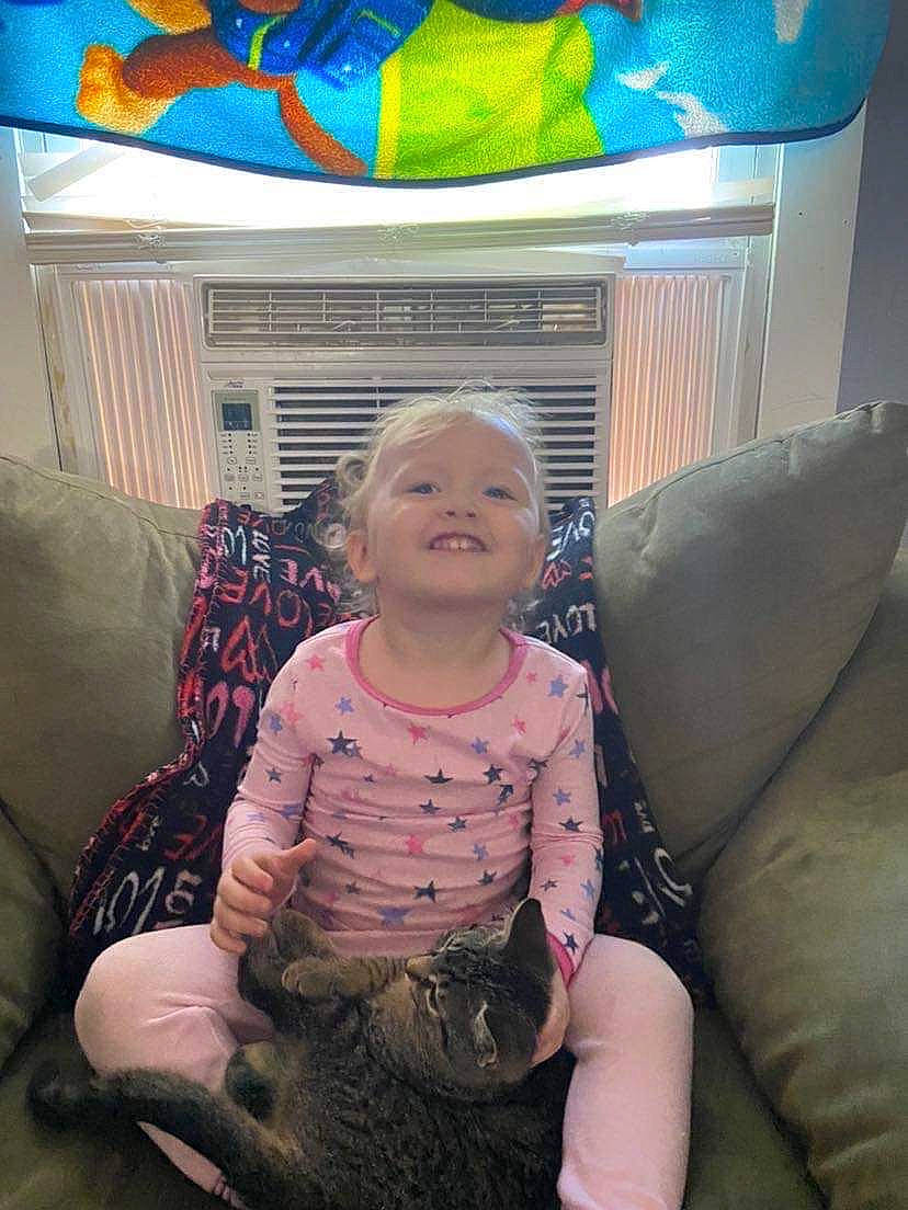 Ivory is registered to the contest to win money with this photo: baby_toddler_clothing, black, blue, child, comfort, couch, fun, fur, happy, human_leg, joy, lap, living_room, pattern, person, picture_frame, room, sitting, smile, t_shirt