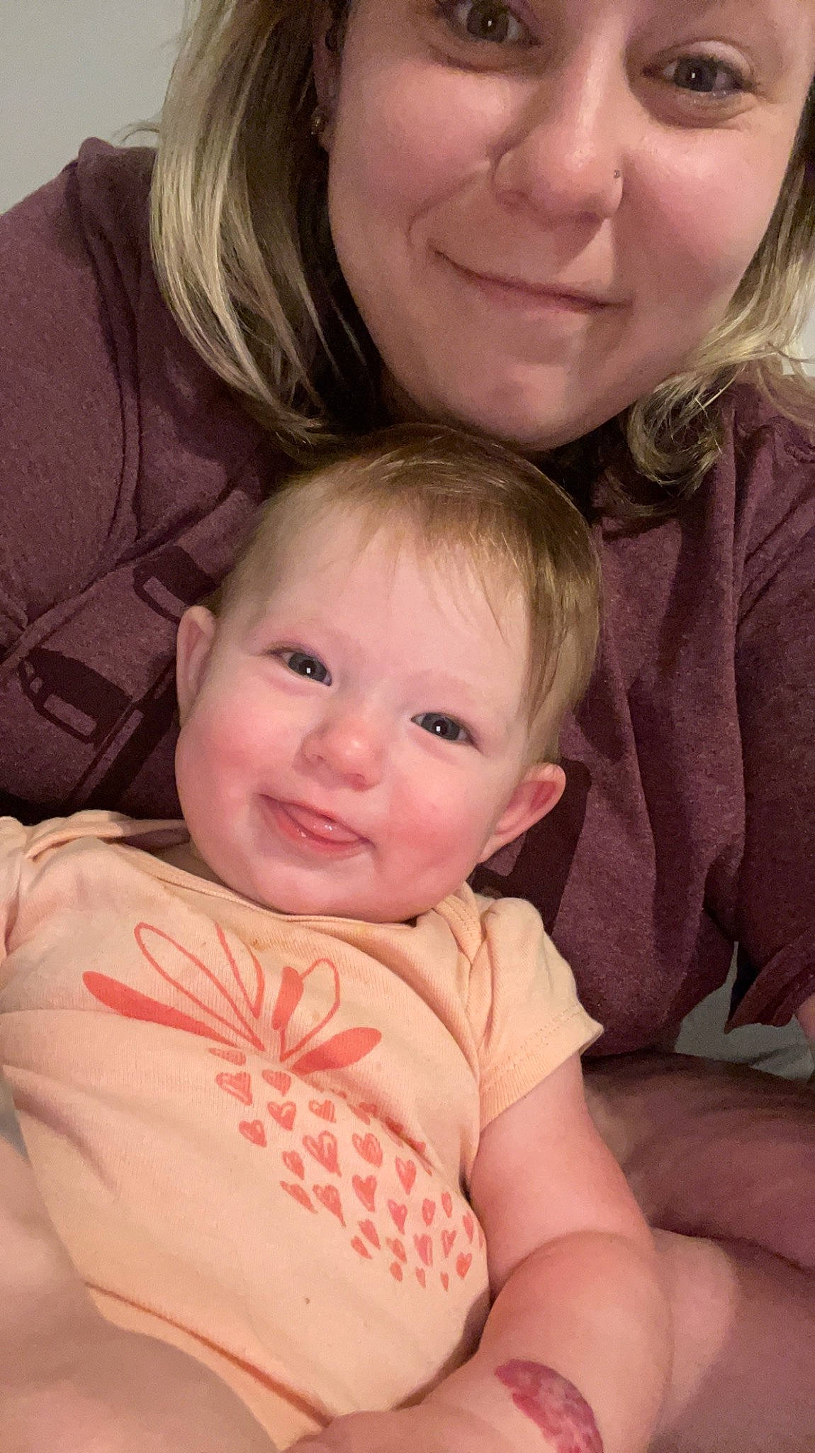 Wren is registered to the contest to win money with this photo: baby, baby_toddler_clothing, blond, cheek, child, comfort, facial_expression, fun, gesture, happy, iris, joy, lip, mouth, nose, organ, person, pink, sitting, skin