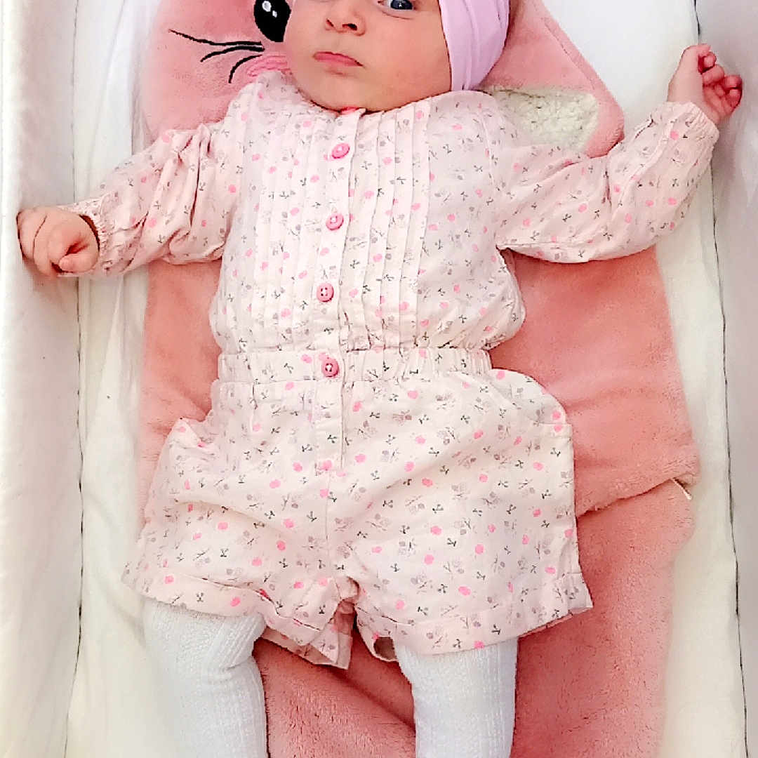 Orlane a rejoint le concours — aidez-le/la à gagner de superbes lots ! adorable, baby, baby_clothes, baby_girl, bunny_pillow, child, childhood, crib, cute, headwear, indoor, infant, lying_down, person, pink_headband, pink_outfit, resting, sleeping_area, soft_bedding, white_tights