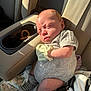 baby, infant, car_seat, socks, mittens, sunlight, car_interior, seat, clothing, person, cute, newborn, expression, seatbelt, travel, child, portrait, skin, head, resting