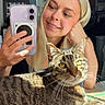 Willow joined the competition — help win amazing prizes! blonde_hair, casual, cat, cozy, feline, friendly, happy, home, indoor, pet, phone, portrait, reflection, relaxed, selfie, smiling, sunlight, tabby_cat, table, woman