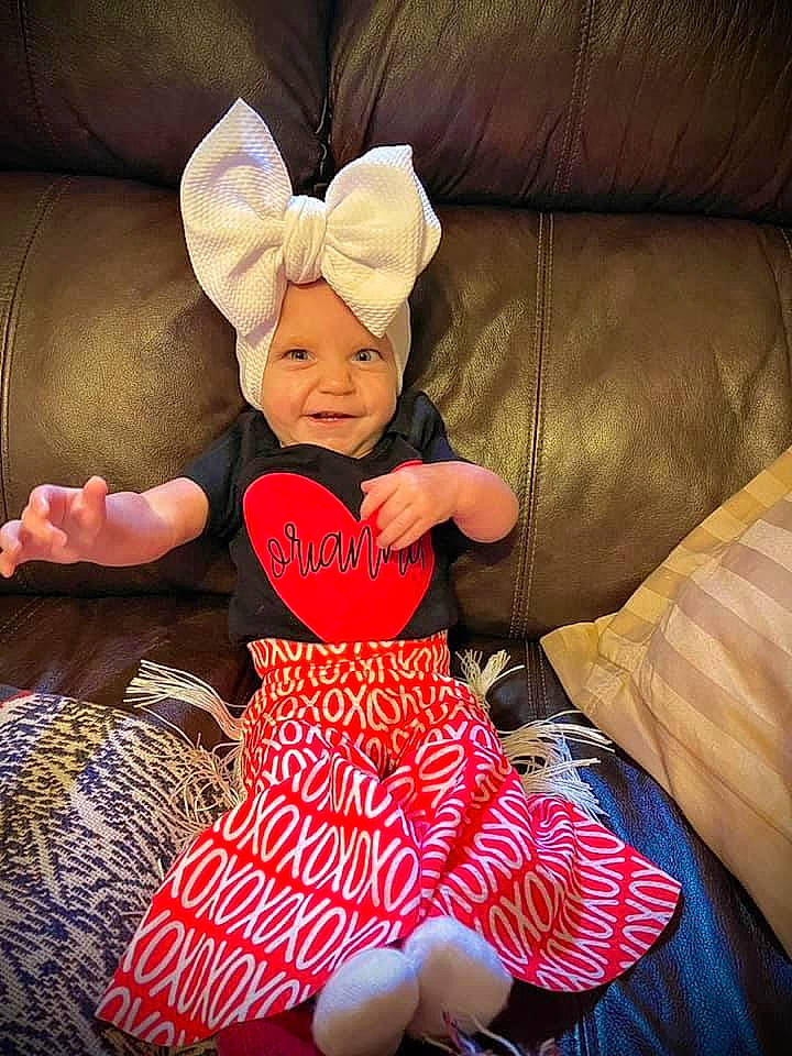 Orianna joined the competition — help win amazing prizes! baby, baby_toddler_clothing, child, comfort, costume_hat, couch, event, happy, hat, head, headwear, holiday, human_body, human_leg, joy, lap, linens, person, sleeve, t_shirt