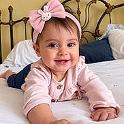 Antonella joined the competition — help win amazing prizes! baby, child, infant, smiling, happy, portrait, pink_outfit, headband, bunny, bow, bed, bedroom, pillow, blanket, headboard, indoor, lying_down, crawling, close_up, family_photo