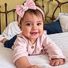 baby, child, infant, smiling, happy, portrait, pink_outfit, headband, bunny, bow, bed, bedroom, pillow, blanket, headboard, indoor, lying_down, crawling, close_up, family_photo