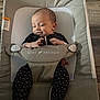 baby, baby_delight, bouncer, child, comfort, cute, fabric, face, feet, hands, indoor, infant, newborn, onesie, person, relaxed, seat, smiling, star_pattern, wood_floor