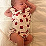 apparel, baby, blanket, child, clothing, cute, face, foot, hand, head, indoor, infant, newborn, peaceful, person, quilt, relaxing, skin, sleeping, strawberry_pattern