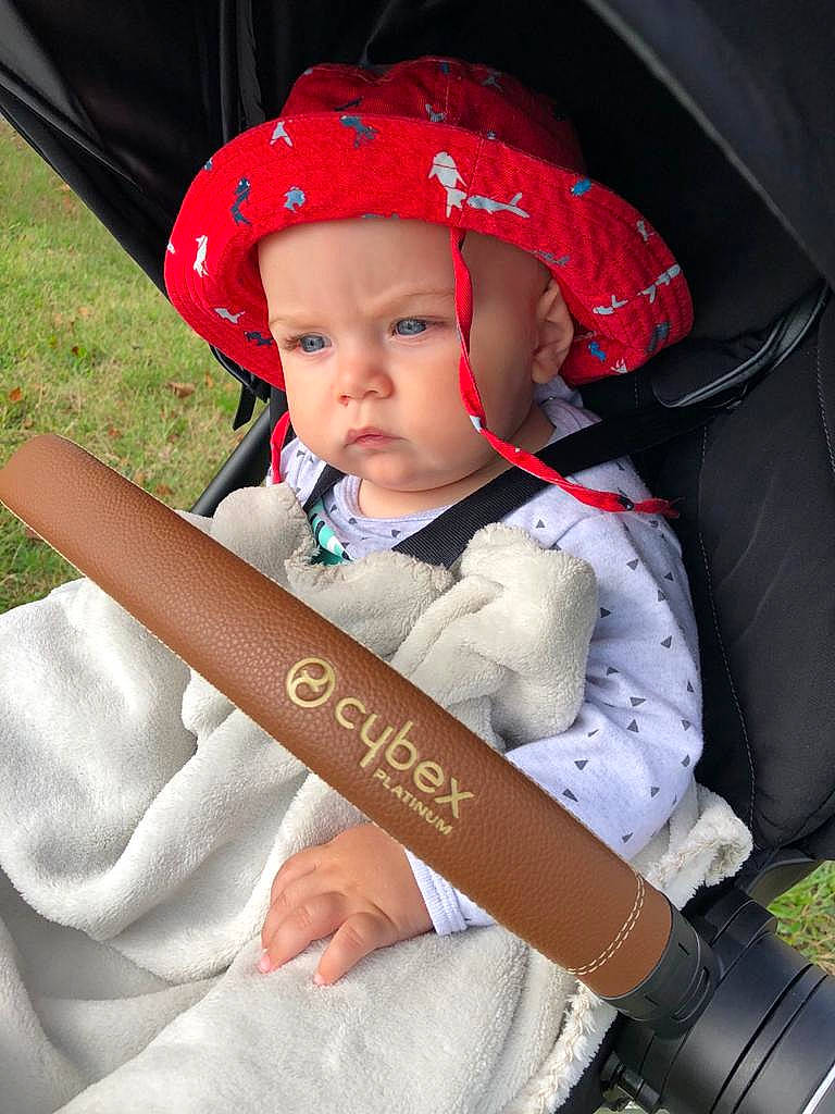 Mylan participe au concours pour gagner de l'argent avec cette photo : baby, baby_carriage, baby_products, baby_toddler_clothing, cap, carmine, chair, child, costume_hat, fashion_accessory, fun, grass, hat, headwear, person, personal_protective_equipment, product, recreation, sitting, sun_hat