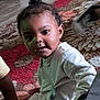 Kelvin joined the competition — help win amazing prizes! baby, infant, child, pajamas, topknot, carpet, rug, floor, hand, shoe, indoors, cute, young_child, person, sitting, curious, home, cozy, black_hair, playtime
