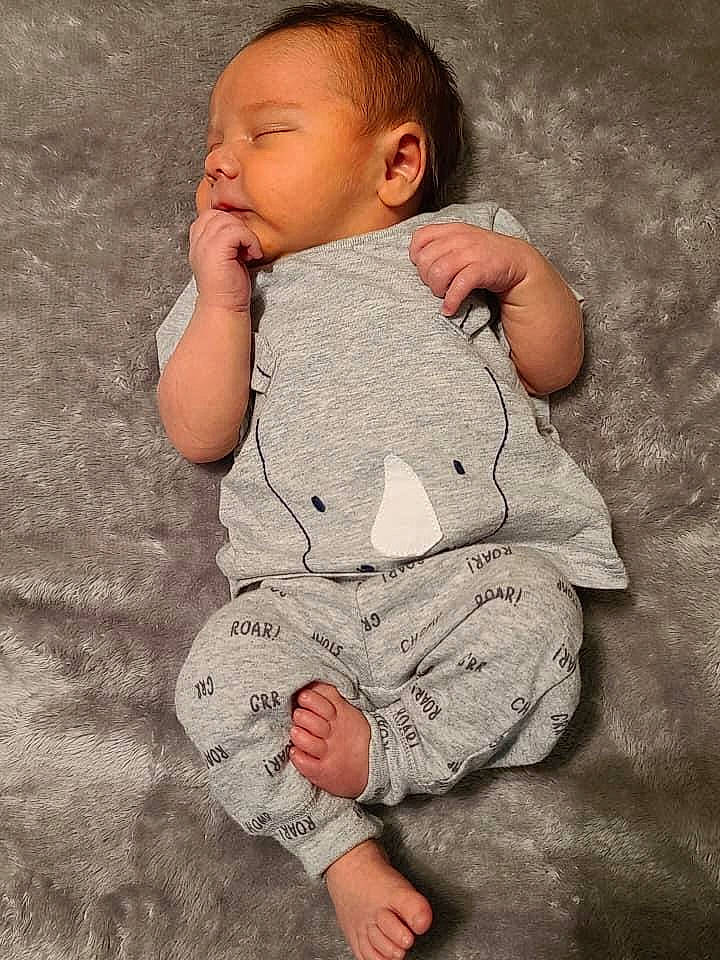 Austyn is registered to the contest to win money with this photo: arm, baby, baby_toddler_clothing, cheek, chin, comfort, eye, face, grass, hand, head, human_body, iris, leg, lip, nose, person, skin, sleeve, textile