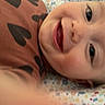 baby, smiling, face, closeup, heart_pattern, clothing, infant, happy, child, portrait, lying_down, blanket, cute, skin, eyes, mouth, cheeks, expression, baby_girl, baby_boy