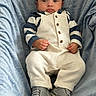 baby, infant, child, portrait, sitting, serious, cap, hat, overalls, striped_shirt, sneakers, shoes, blue_chair, upholstery, patterned_fabric, indoor, fashion, closeup, front_facing, cozy
