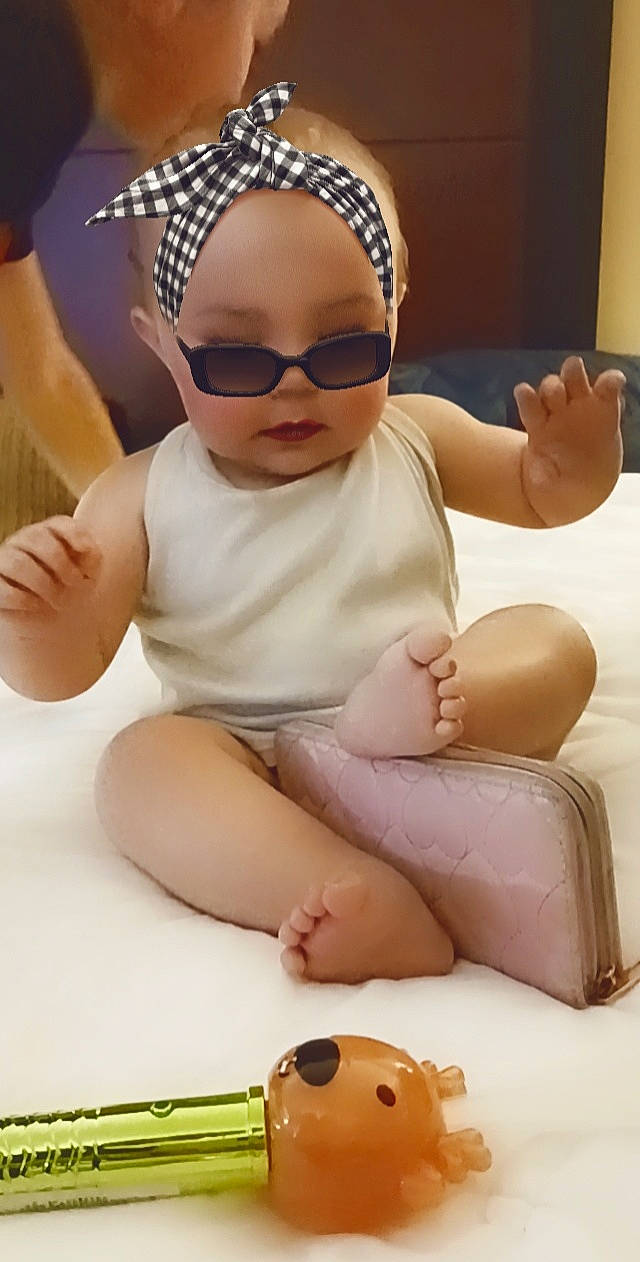 Briella is registered to the contest to win money with this photo: baby, baby_toddler_clothing, cap, child, comfort, eyewear, finger, glasses, headwear, joint, knee, mouth, neck, person, skin, sleeve, thigh, thumb, toddler, vision_care