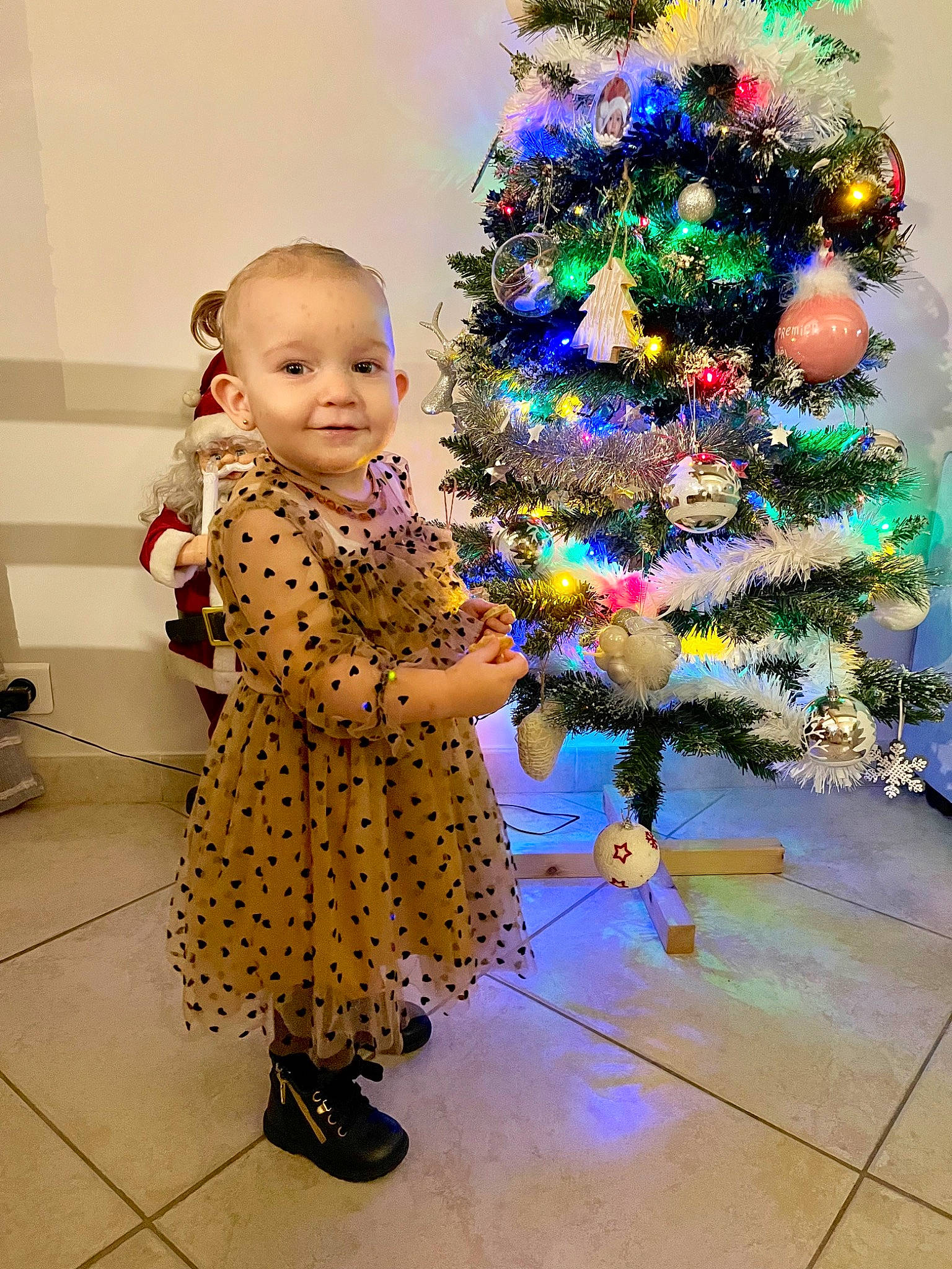 Léna a rejoint le concours — aidez-le/la à gagner de superbes lots ! baby, baby_toddler_clothing, christmas_decoration, christmas_ornament, christmas_tree, event, evergreen, flooring, fun, happy, holiday_ornament, joy, ornament, people_in_nature, person, plant, purple, sandal, smile, standing