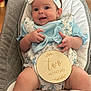 Hallie is registered to the contest to win money with this photo: baby, infant, smiling, headband, blue_clothing, milestone_sign, two_months, baby_seat, cushion, happy, cute, portrait, indoor, child, person, skin, legs, hands, socks, fabric
