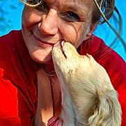 Princess is registered to the contest to win money with this photo: woman, dog, close_up, outdoor, red_shirt, pink_harness, sunlight, smiling, affection, pet, canine, human, face, love, nature, blue_sky, tree, fur, happy, portrait