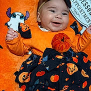 Emine joined the competition — help win amazing prizes! baby, smiling, halloween, pumpkin, bat, orange_clothing, headband, blanket, cartoon_ghost, cute, festive, infant, happy, costume, black_skirt, patterned_clothing, baby_girl, lying_down, indoor, celebration